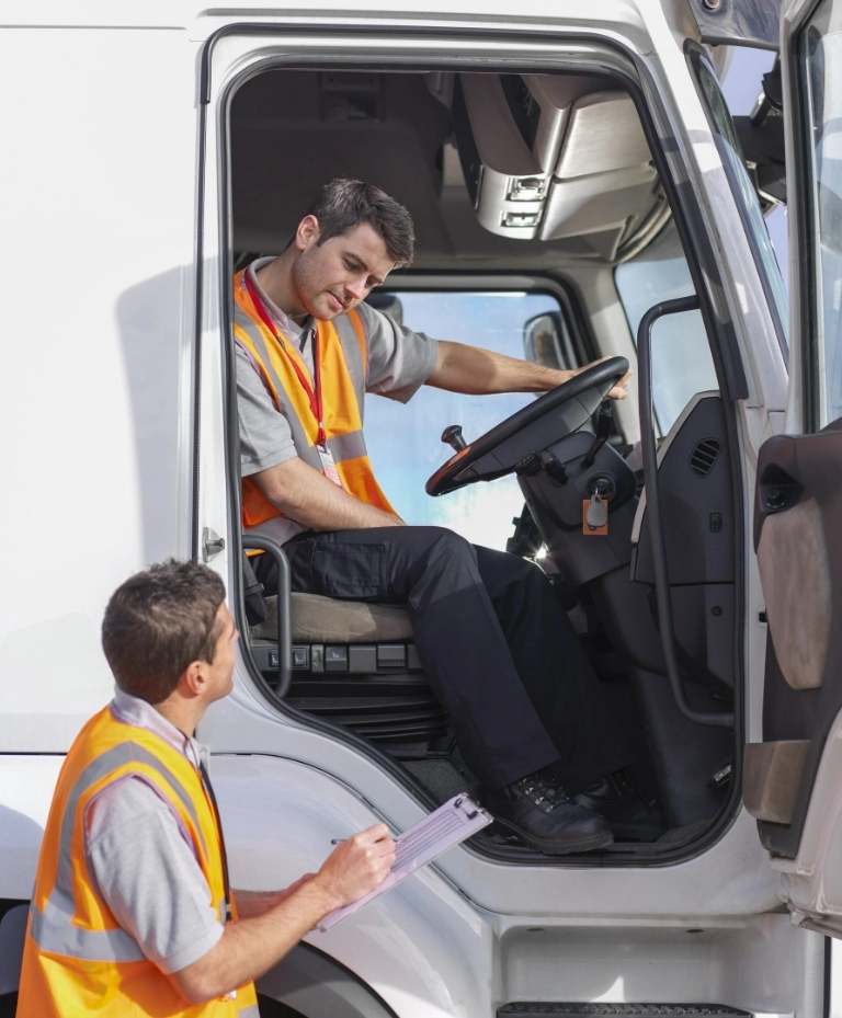 dwóch pracowników przy ciężarówce