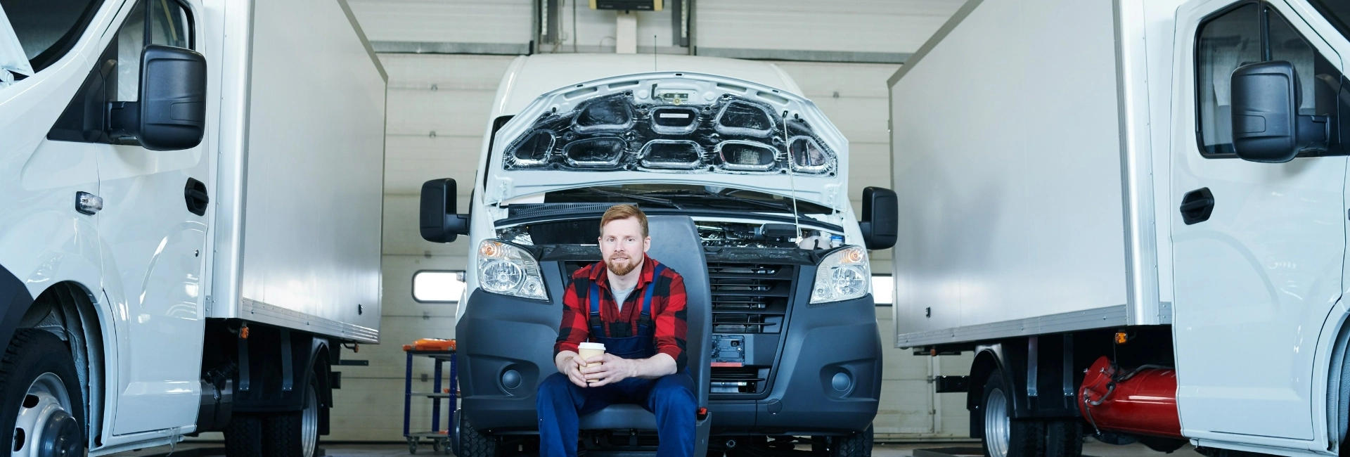 mężczyzna w koszuli w kratę siedzący przed samochodem